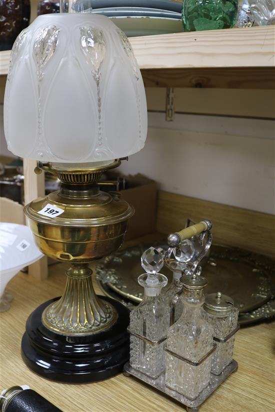 A brass oil lamp and a cruet and plated wares and two brass trays